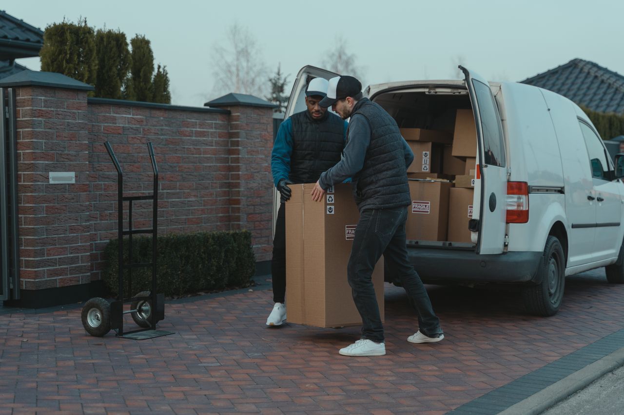 Delivery team handling packages from van in suburban area.